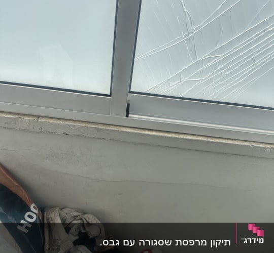 חלון שבור עם חפצים שונים על הרצפה